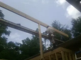 Carpenter setting a ridge beam over a new addition frame — Ice Dam Removal by Roofing Brothers in Kettle Falls