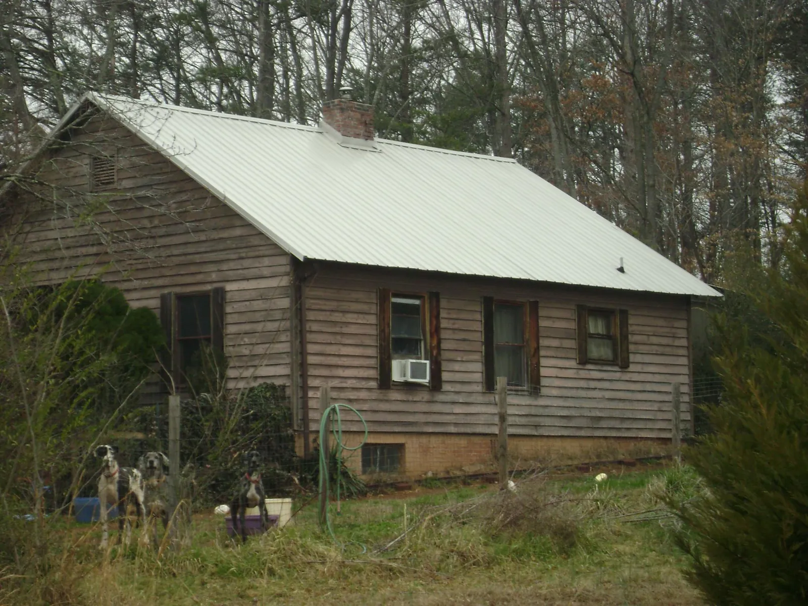 White metal roof on an old wood sided farmhouse, from a Metal Roof Installation job in Kettle Falls